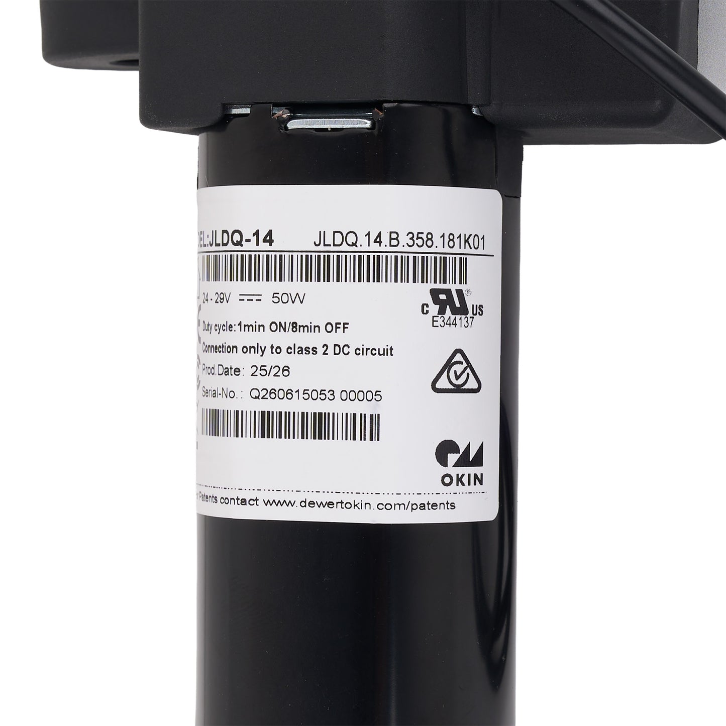 Close-up of a black cylindrical electrical component with a white product label showing barcodes, specifications, and the Okin brand logo.
