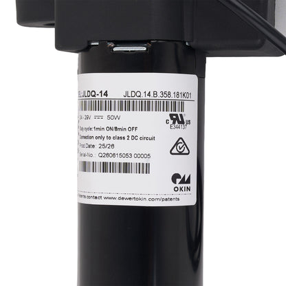 Close-up of a black cylindrical electrical component with a white product label showing barcodes, specifications, and the Okin brand logo.