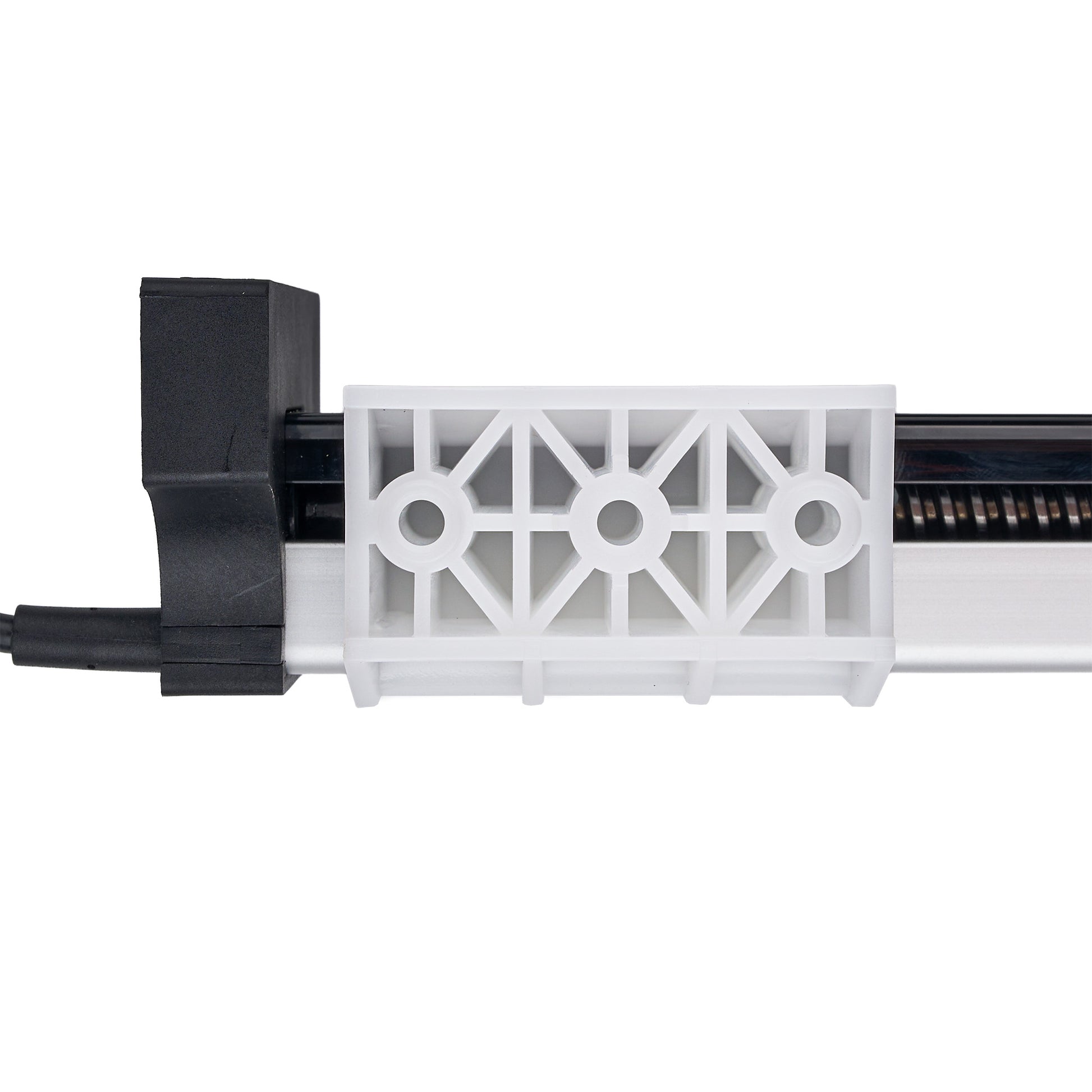 A close-up of a white plastic vent-like component with a geometric openwork pattern, attached to a black and silver mechanical housing on a plain white background.