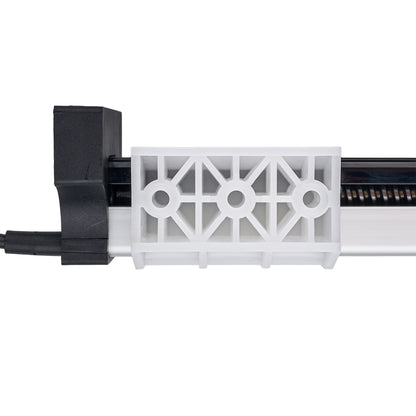 A close-up of a white plastic vent-like component with a geometric openwork pattern, attached to a black and silver mechanical housing on a plain white background.