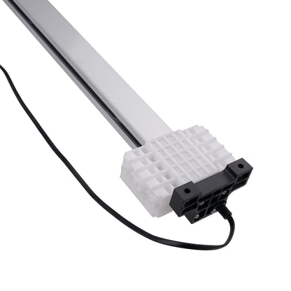 A linear LED light bar with a silver aluminum housing, a white ribbed heat sink, and a black connector block, shown with its attached black power cable on a white background.