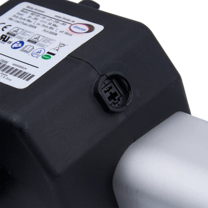 Close-up of a black battery pack with a label and connector on a white background