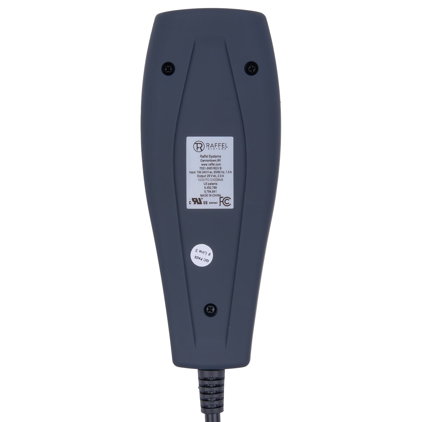 The back of a dark gray NexGen electronic device, showing a white product specification label, a small circular sticker, and screw holes, with a black power cord extending from the bottom.