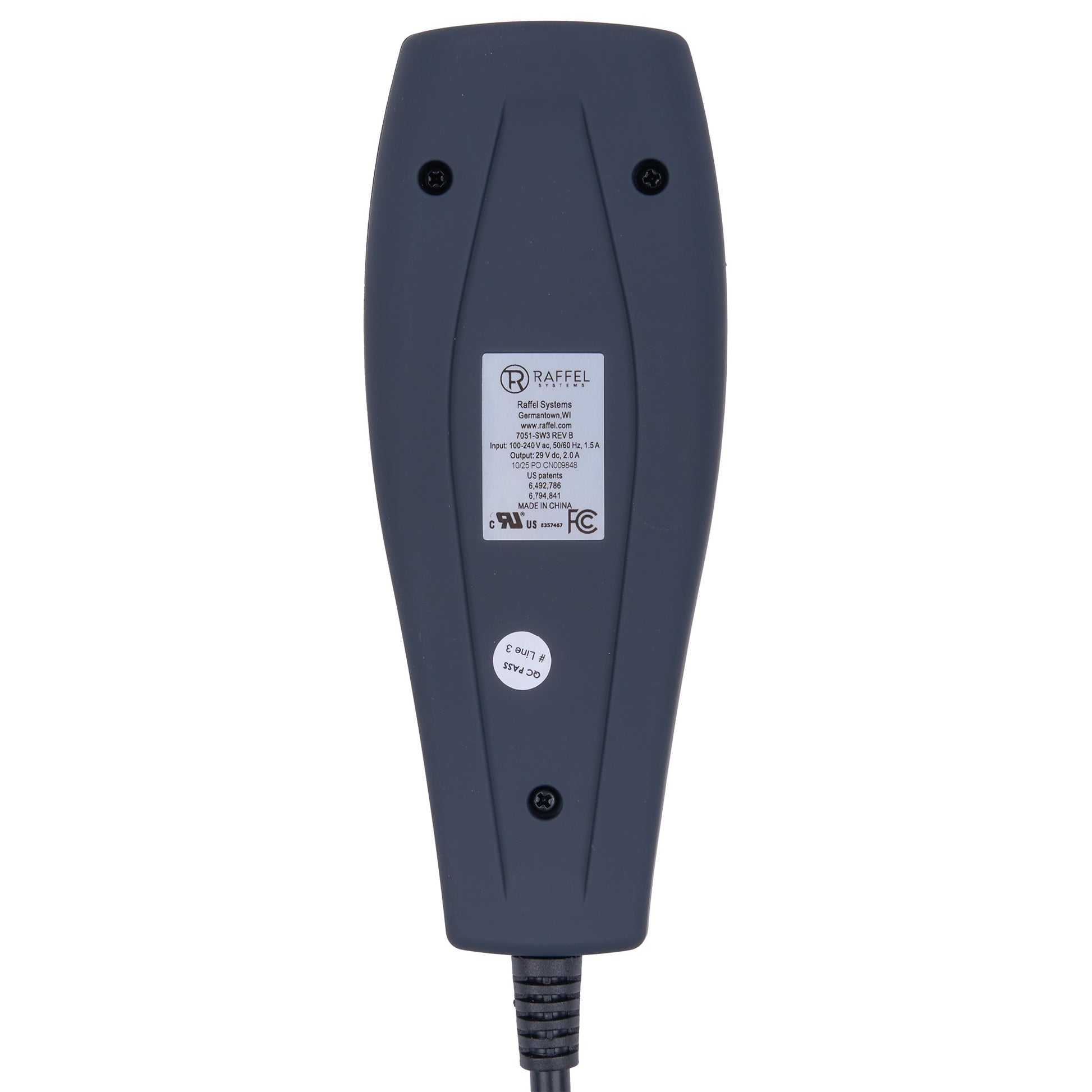The back of a dark gray NexGen electronic device, showing a white product specification label, a small circular sticker, and screw holes, with a black power cord extending from the bottom.