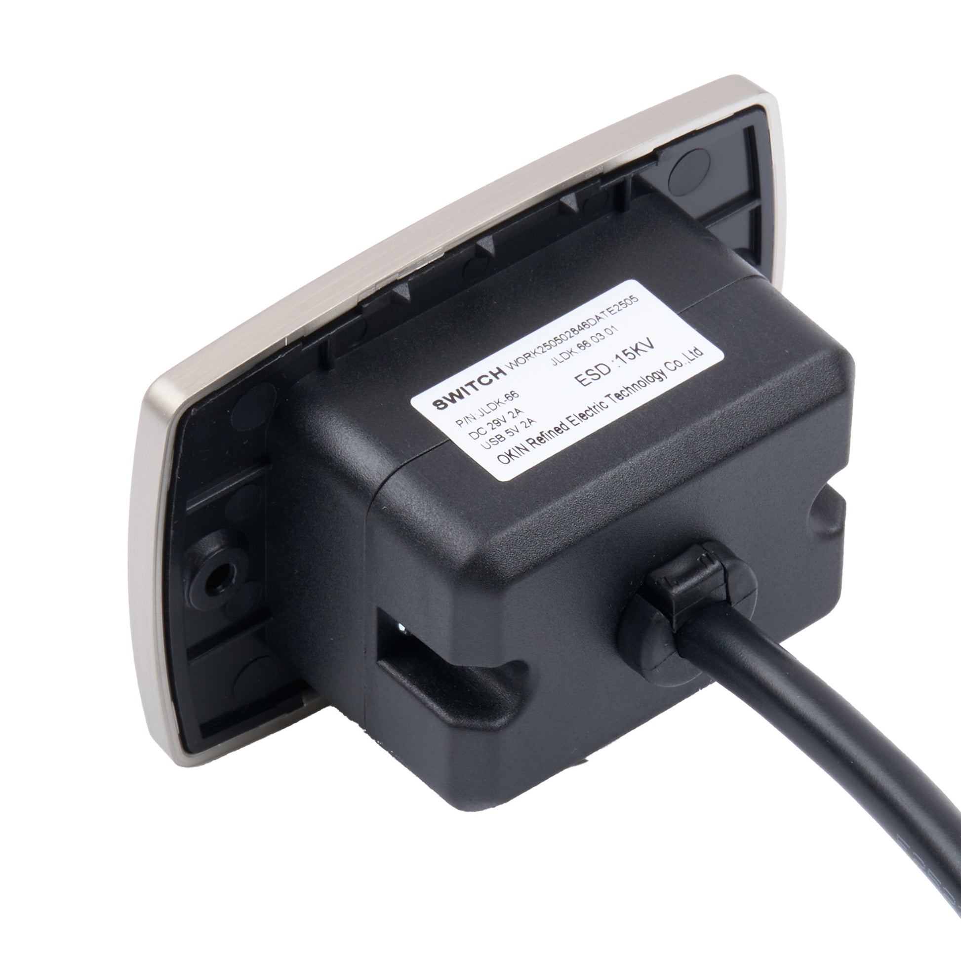 A black electrical switch module with a silver metal backplate and a black power cord, shown on a white background. A white label on the side displays technical specifications.
