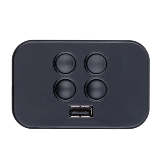 A black rectangular electronic control module with rounded corners, featuring four circular buttons arranged in a 2x2 grid and a USB-A port at the bottom center, shown on a plain white background.