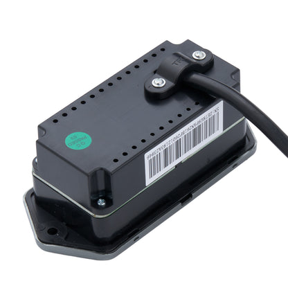 A black rectangular electronic module with a barcode label, a green circular sticker, and a black cable connected at the top, photographed on a plain white background.