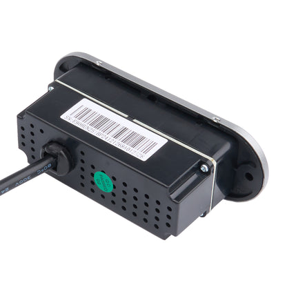 A black electronic sensor or control module with a silver metal mounting bracket, a barcode label, a green circular sticker, and a black cable connected, shown on a white background.