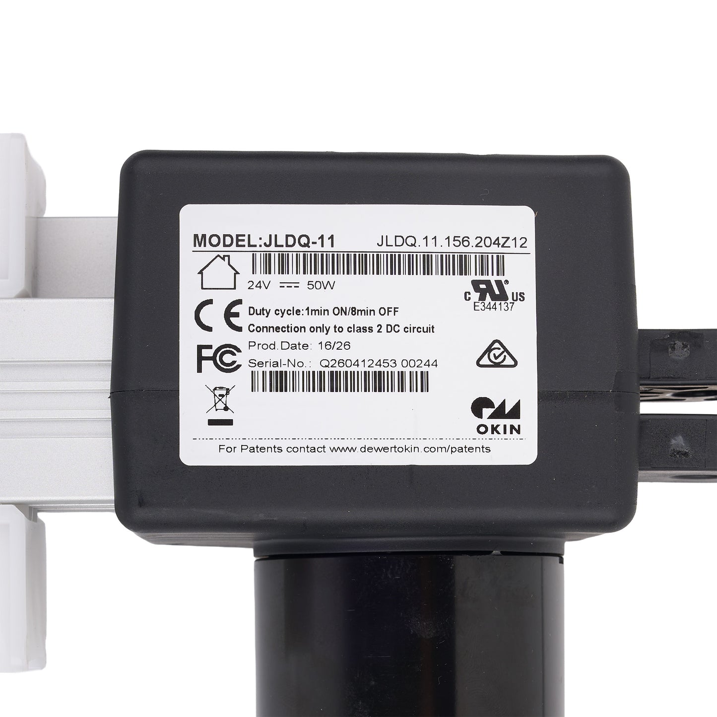 A close-up of a black electronic component with a white label showing model JLDQ-11 and OKIN branding, mounted on a white and black frame against a white background.