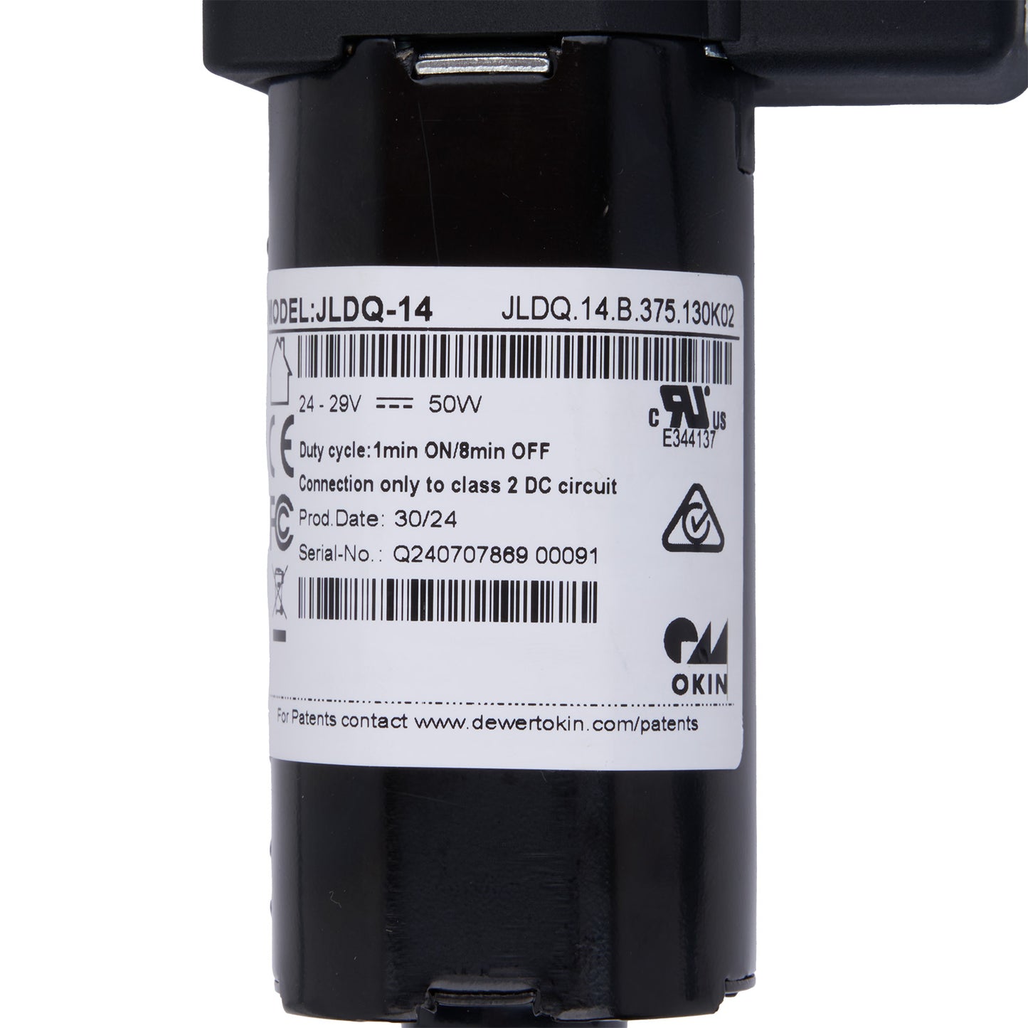 Black cylindrical device with a label on a white background