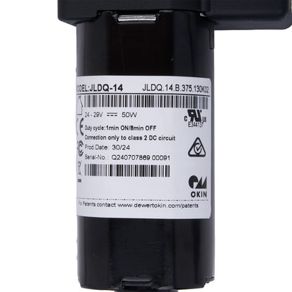 Black cylindrical device with a label on a white background