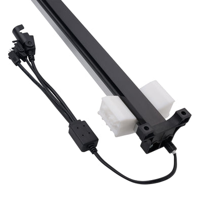 A black linear rail assembly with white plastic end blocks and attached black wiring harnesses, photographed on a plain white background.