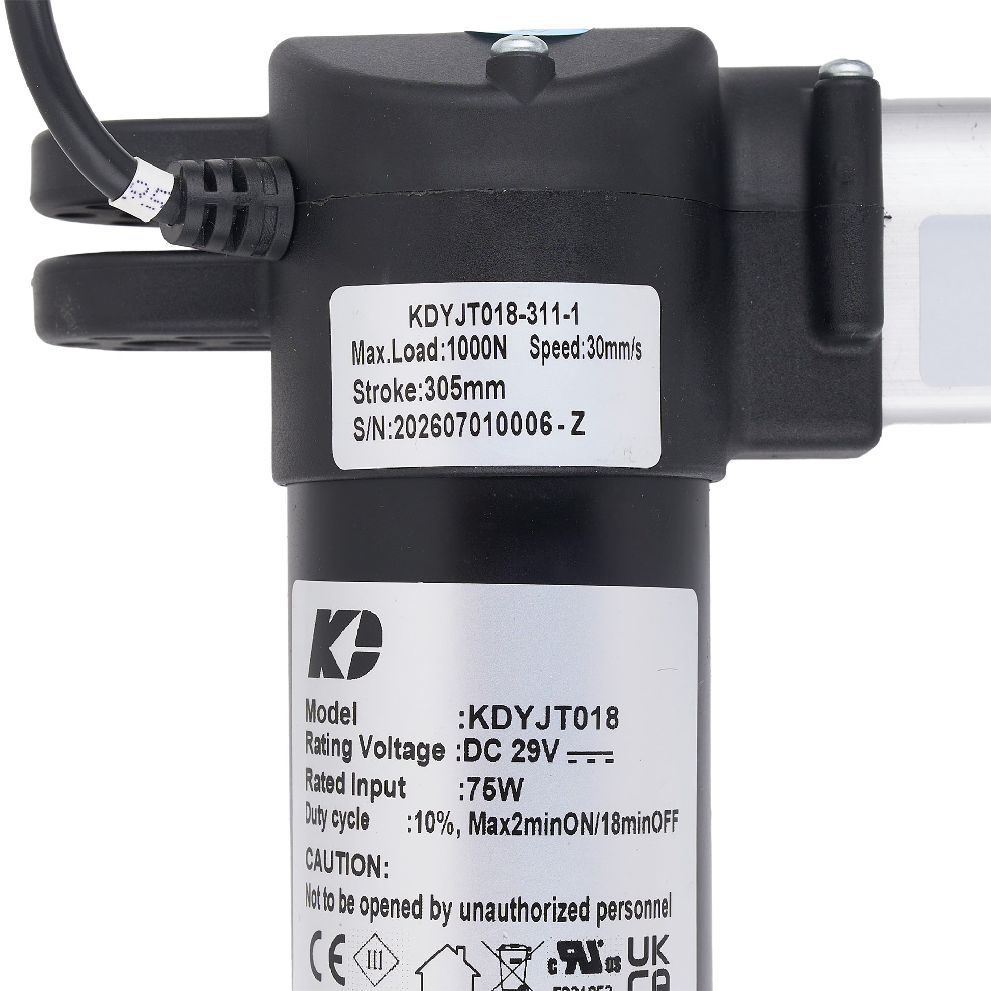 Close-up of a black cylindrical electric pump or motor component with attached cable, top mounting bracket, and two white product labels showing model and technical specifications.