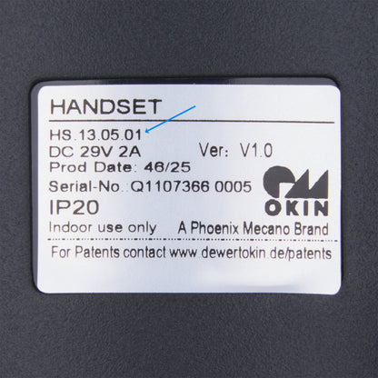 A close-up of a white product label on a dark gray surface, showing text including 'HANDSET', 'OKIN', 'Phoenix Mecano Brand', and 'A PHOENIX MECANO BRAND'.