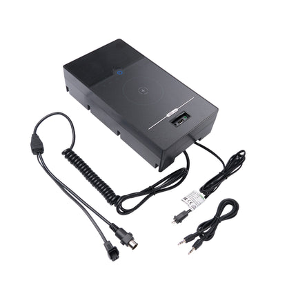 A black rectangular electronic device with a coiled cable and power adapters, photographed on a plain white background.